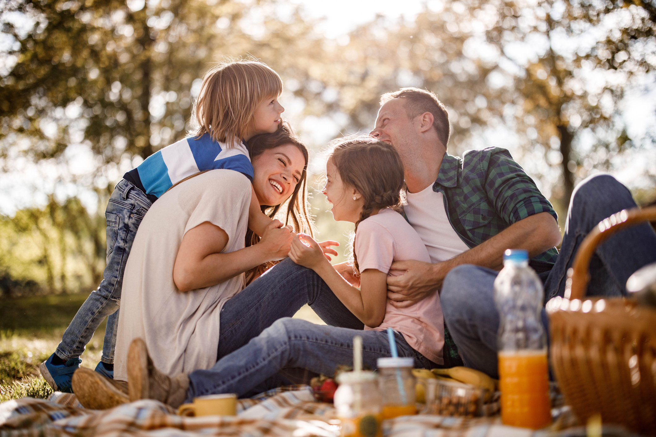 Cheerful family having fun on a picnic in spring day.