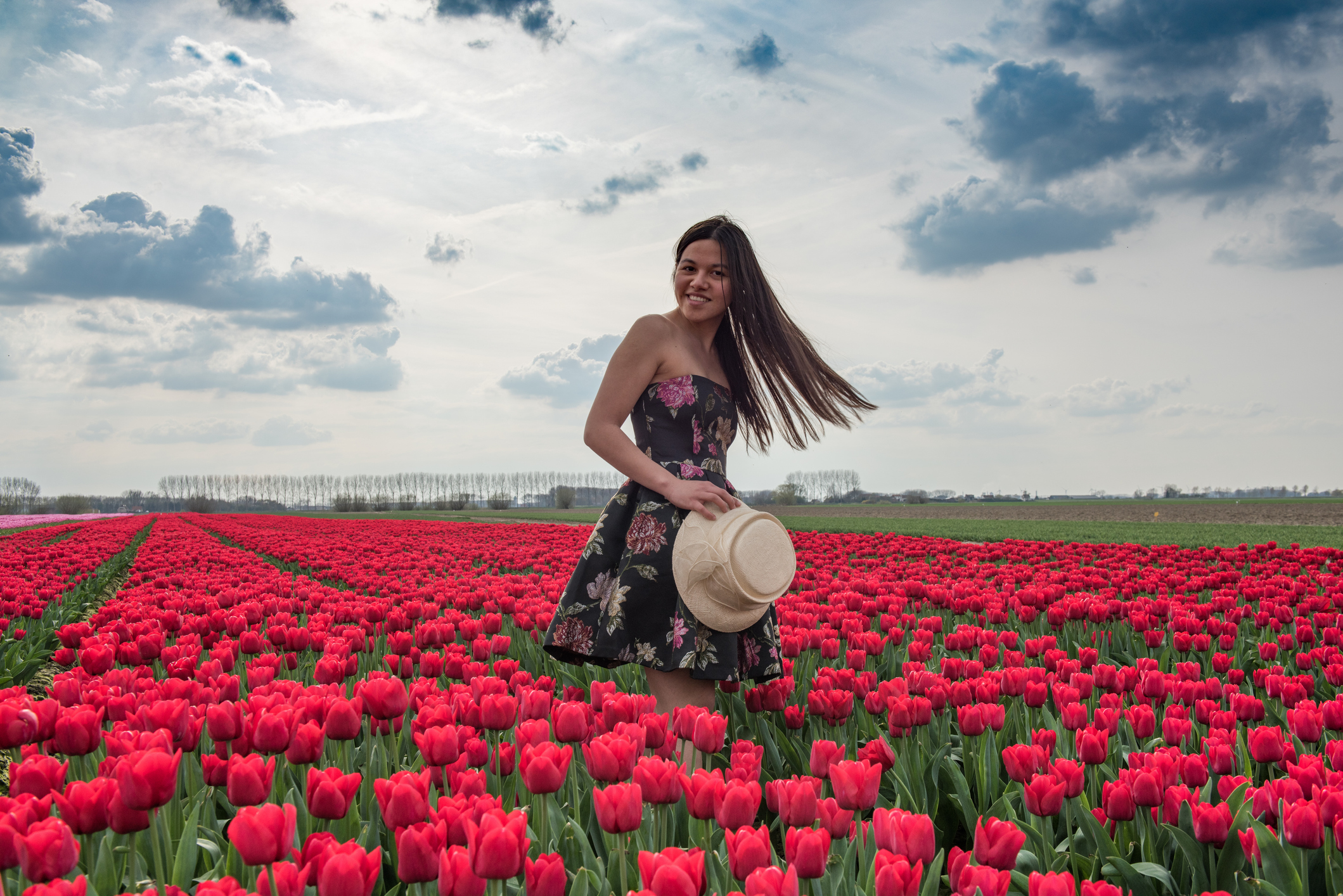 Pretty woman standing in a field of red tulips
