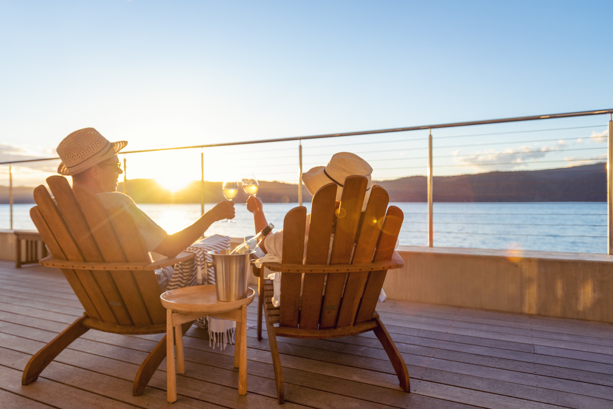 Couple relaxing and drinking wine and toasting on deck chairs