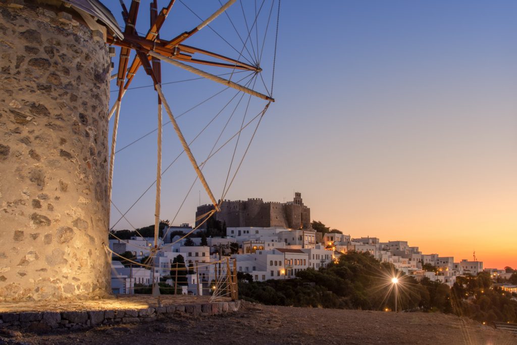 The three windmills of Chora and iconic Monastery of Saint John the Theologian in chora of Patmos island, Dodecanese, Greece